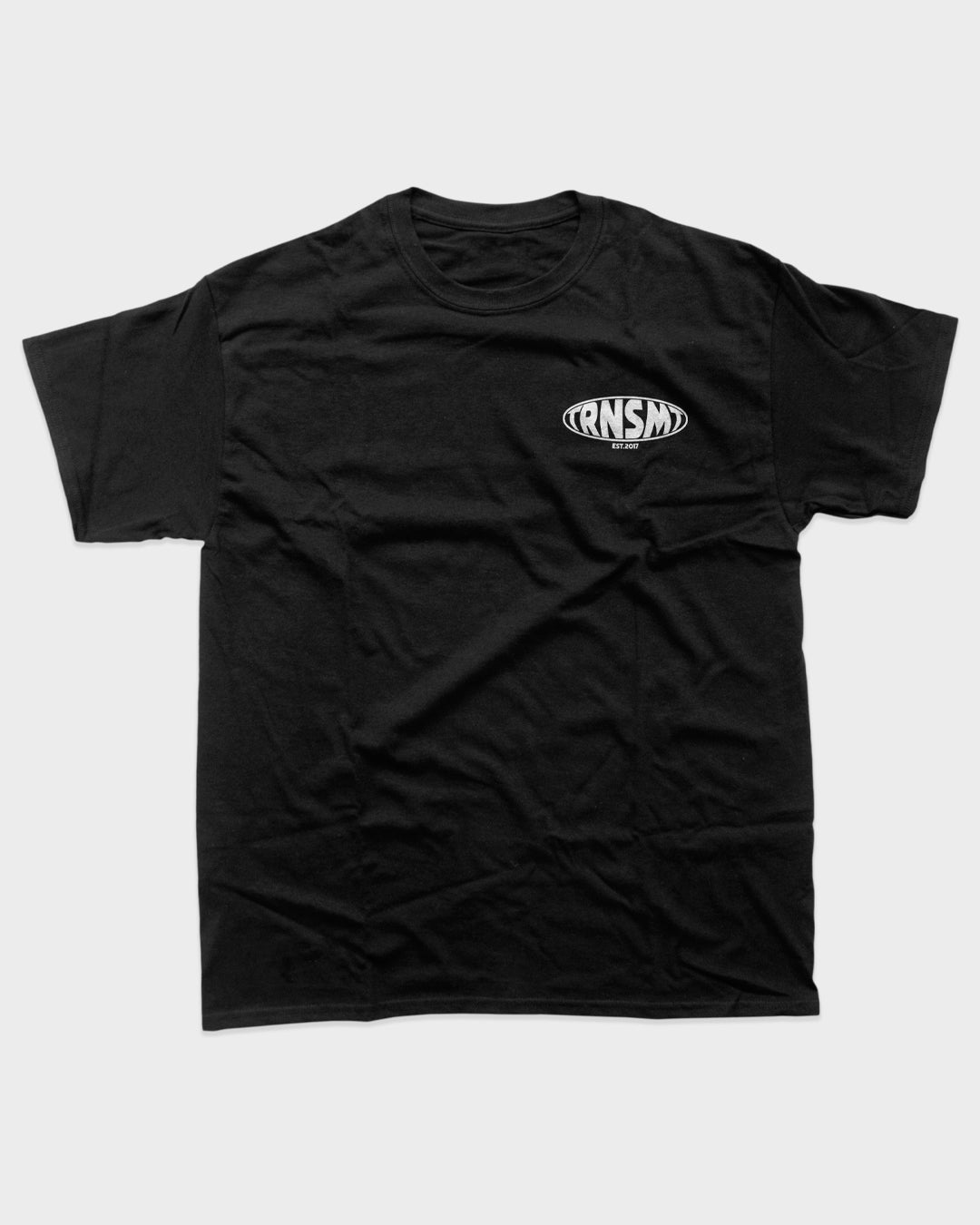 The TRNSMT 2025 Line-Up T-Shirt by TRNSMT Festival is a unisex fit, plain black DTG tee with a small white RNSM logo inside an oval on the left chest. Made from soft Airlume cotton, its shown laid flat on a light grey background.